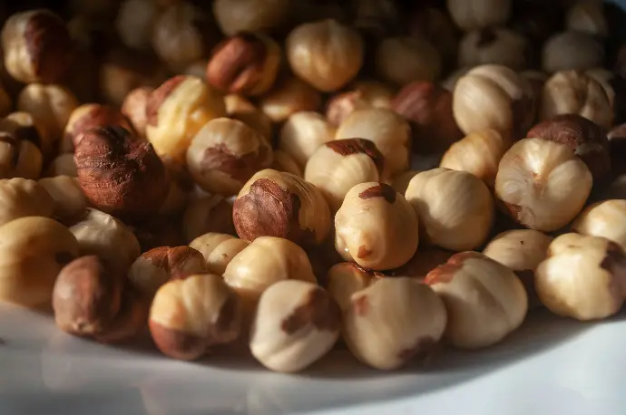 a white plate topped with nuts on top of a table